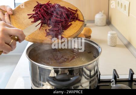 In Streifen geschnittene Rote Bete wird in einen Topf gegeben, um Borsch, ein ukrainisches Nationalgericht, zu machen. Stockfoto