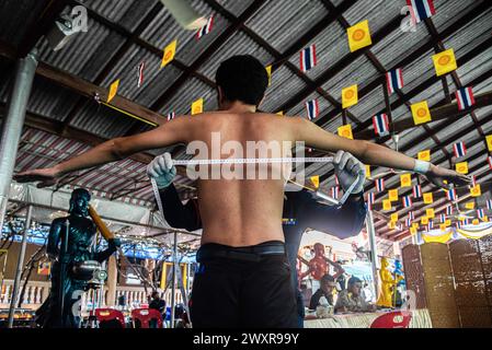Bangkok, Thailand. April 2024. Bei einem Thai-Mann wird seine Brust von einem Militärangehörigen während eines jährlichen Militärzugs im Wat Samakchhitham gemessen. Die Royal Thai Armed Forces starteten ihre jährliche Wehrpflicht mit der Suche nach gesunden Männern ab 21 Jahren aus dem ganzen Land vom 1. April 2024 bis zum 12. April 2024, indem sie freiwillig und im Lotto eine Lotterie verzeichneten. (Foto: Peerapon Boonyakiat/SOPA Images/SIPA USA) Credit: SIPA USA/Alamy Live News Stockfoto