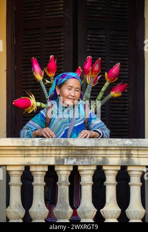 Blume Hmong Frau mit einem Korb mit Blumen im Hmong Königspalast (Vau Meo) in Bac Ha, Lao Cai Provinz, Vietnam Stockfoto