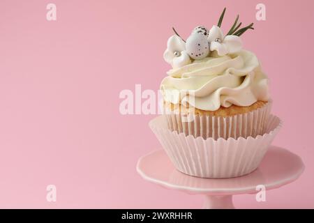 Leckerer Oster-Cupcake mit Vanillecreme auf rosa Hintergrund, Platz für Text Stockfoto