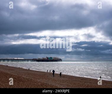 Brighton UK 1. April 2024 - die Sonne versucht am Ostermontag durch dunkle Wolken über dem Brighton Palace Pier zu schauen : Credit Simon Dack Stockfoto