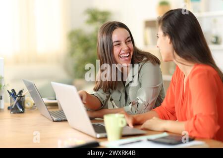 Zwei Telearbeiter reden und lachen, vergeuden zu Hause Zeit Stockfoto