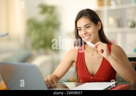 Glücklicher Student, der zu Hause Kaugummi isst Stockfoto