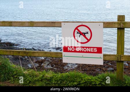 Schild "keine Drohnen" auf einem hölzernen Zaun in der Nähe eines öffentlichen Weges neben einem Strand Stockfoto