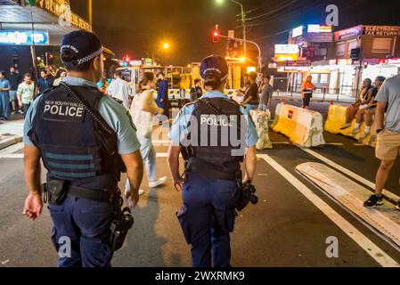 Zwei Polizisten laufen während des Ramadan und des Ramadan Nights Festivals 2024 in Haldon Street Lakemba, Sydney, Australien Stockfoto