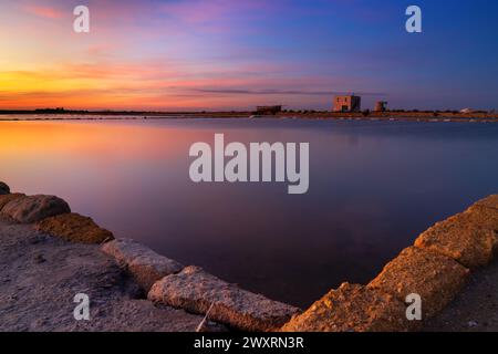 Blick auf die Landschaft der ruhigen Meersalzbecken und -Ebenen in der Nähe von Trapani und Paceco bei Sonnenuntergang Stockfoto