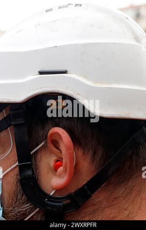 Ein Mann, der einen weißen Helm trägt und eine Maske trägt Stockfoto