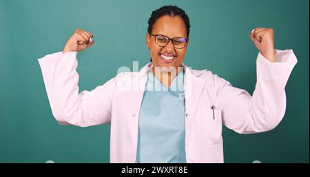 Der schöne junge Schwarze Doktor spannt die Armmuskeln, starke Frauenbefähigung Stockfoto