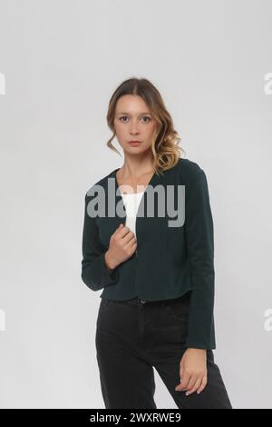 Serie von Studiofotos eines jungen weiblichen Models mit bequemem, elegantem, legeren Outfit, schlichtem, minimalistischem Blazer und Jeanshose Stockfoto