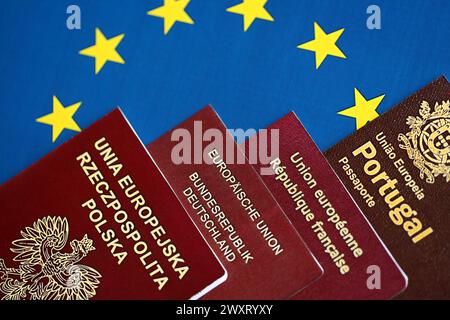 eu-Länder Pässe auf blauer EU-Flagge aus nächster Nähe. Portugiesische, deutsche, französische und polnische Reisepässe Stockfoto