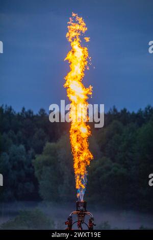 Sunset Glow: Gas Burner Fire wirft einen warmen Farbton auf den Abendhimmel Stockfoto