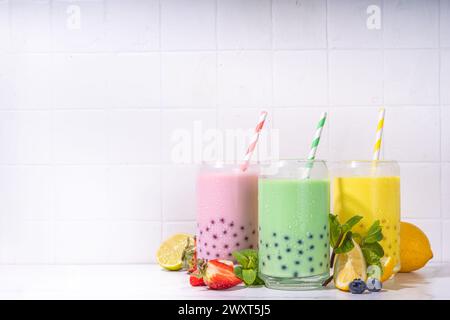 Set mit drei farbenfrohen Sommerblase-Tees, hellen cremigen Perlentee oder Latte Tapioka-Getränken, Rosa Beere, gelben Zitrusfrüchten, grüner Minze, mit Tapiokugeln und Stockfoto