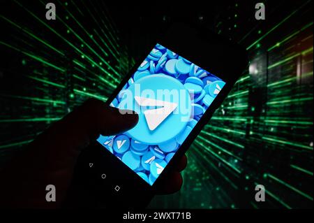 Polen. April 2024. In dieser Abbildung wird auf einem Smartphone ein Telegram-Logo mit Codierung im Hintergrund angezeigt. Quelle: SOPA Images Limited/Alamy Live News Stockfoto