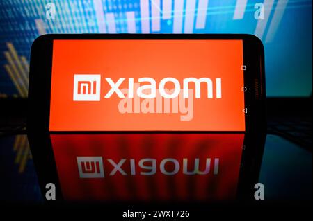 Polen. April 2024. In dieser Fotoabbildung wird ein Xiaomi-Logo auf einem Smartphone mit Aktienmarktanteilen im Hintergrund angezeigt. Quelle: SOPA Images Limited/Alamy Live News Stockfoto