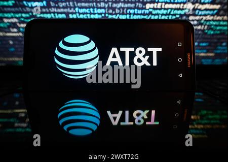 Polen. April 2024. In dieser Fotoabbildung wird auf einem Smartphone ein AT&T-Logo mit Codierung im Hintergrund angezeigt. Quelle: SOPA Images Limited/Alamy Live News Stockfoto