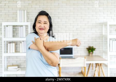 Eine schöne und lächelnde asiatische Frau beim Heimtraining Stockfoto