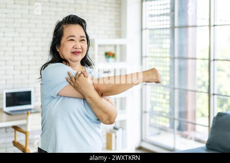 Eine schöne und lächelnde asiatische Frau beim Heimtraining Stockfoto