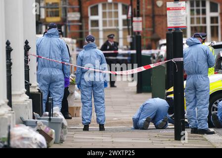 Gerichtsmediziner am Tatort in der Comeragh Road, West Kensington, West London, nachdem ein Mann am Ostermontag erschossen wurde. Beamte reagierten auf eine gemeldete Störung in einer Wohnadresse um 22:17 Uhr am Montagabend. Sanitäter behandelten einen 21-jährigen Mann wegen einer Schusswunde, aber er starb am Tatort kurz vor 23 Uhr. Bilddatum: Dienstag, 2. April 2024. Stockfoto