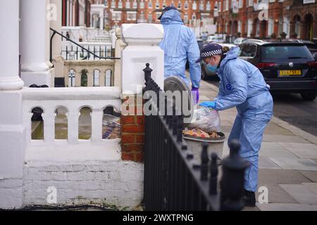 Gerichtsmediziner am Tatort in der Comeragh Road, West Kensington, West London, nachdem ein Mann am Ostermontag erschossen wurde. Beamte reagierten auf eine gemeldete Störung in einer Wohnadresse um 22:17 Uhr am Montagabend. Sanitäter behandelten einen 21-jährigen Mann wegen einer Schusswunde, aber er starb am Tatort kurz vor 23 Uhr. Bilddatum: Dienstag, 2. April 2024. Stockfoto