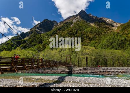 KAMIKOCHI, JAPAN - 24. MAI 2023: Wanderer überqueren die Myojin-Hängebrücke über den Azusa-Fluss in Kamikochi, Nagano, Japan Stockfoto