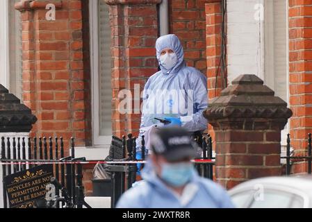 Gerichtsmediziner am Tatort in der Comeragh Road, West Kensington, West London, nachdem ein Mann am Ostermontag erschossen wurde. Beamte reagierten auf eine gemeldete Störung in einer Wohnadresse um 22:17 Uhr am Montagabend. Sanitäter behandelten einen 21-jährigen Mann wegen einer Schusswunde, aber er starb am Tatort kurz vor 23 Uhr. Bilddatum: Dienstag, 2. April 2024. Stockfoto
