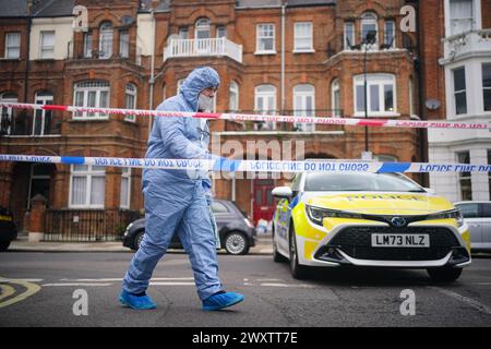 Ein Gerichtsmediziner am Tatort in der Comeragh Road, West Kensington, West London, nachdem ein Mann am Ostermontag erschossen wurde. Beamte reagierten auf eine gemeldete Störung in einer Wohnadresse um 22:17 Uhr am Montagabend. Sanitäter behandelten einen 21-jährigen Mann wegen einer Schusswunde, aber er starb am Tatort kurz vor 23 Uhr. Bilddatum: Dienstag, 2. April 2024. Stockfoto