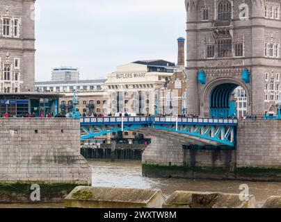 Das denkmalgeschützte Butlers Wharf-Gebäude am Südufer der Themse, das durch die Türme der berühmten London Bridge in London, Großbritannien, gesehen wird Stockfoto