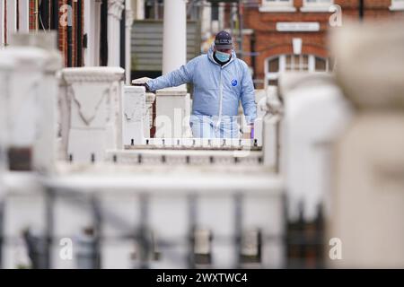 Ein Gerichtsmediziner am Tatort in der Comeragh Road, West Kensington, West London, nachdem ein Mann am Ostermontag erschossen wurde. Beamte reagierten auf eine gemeldete Störung in einer Wohnadresse um 22:17 Uhr am Montagabend. Sanitäter behandelten einen 21-jährigen Mann wegen einer Schusswunde, aber er starb am Tatort kurz vor 23 Uhr. Bilddatum: Dienstag, 2. April 2024. Stockfoto