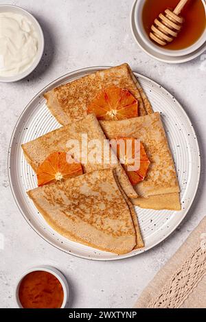 Lebensmittelfotografie von Crepes mit blutiger Orange, Pfannkuchen, Gebäck, Stapel, faschingsdienstag, shrovetide, Honig, Sahne, Joghurt, maslenitsa, dünn, Nachtisch, SW Stockfoto