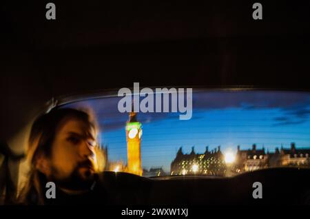 Passagier reflektiert in einem Taxifenster vor dem Hintergrund des beleuchteten Big Ben. Stockfoto