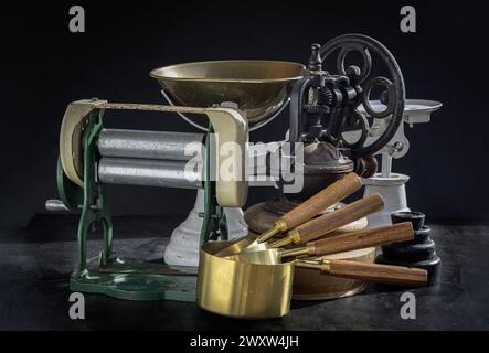 Die antike Kollektion verfügt über eine Nudelmaschine mit Handkurbel, eine originale Kaffeemühle aus Metall mit Handkurbel, eine Waage und Messbecher aus Messing Stockfoto