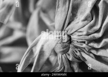 Eine graue Nahaufnahme von geknüpften Stofftüten. Stockfoto