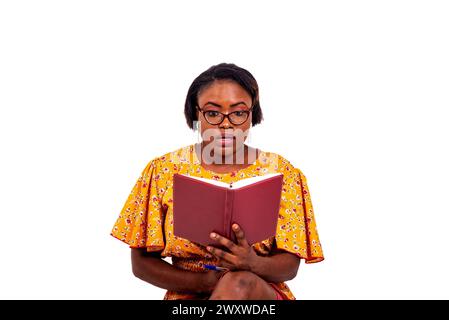 Porträt einer schönen konzentrierten erwachsenen Geschäftsfrau, die eine optische Brille trägt und Notizen im Notizbuch liest. Stockfoto