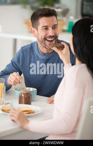 Frau, die ihren geliebten Freund mit Frühstück füttert Stockfoto