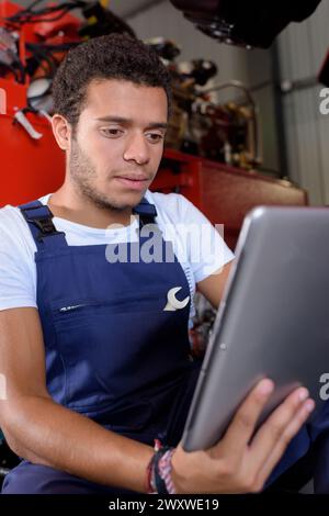 Ein junger Mechaniker mit Tablette Stockfoto