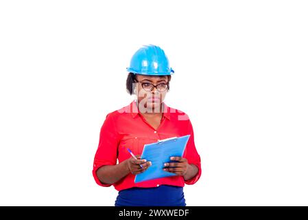 Schöne Ingenieurin mit blauem Schutzhelm, denkt und hält Klemmbrett. Stockfoto