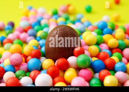 Schokoladen-Osterei umgeben von bunten Kugeln Stockfoto