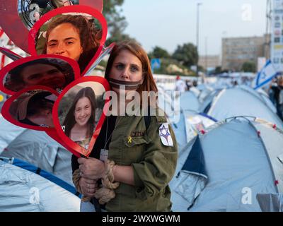 Jerusalem, Israel. April 2024. Ein israelischer Demonstrant verkleidet als israelischer Lot mit festgehaltenem Mund und Seidenhänden protestiert am 2. April 2024 gegen die Freilassung von Geiseln unter Händen von Zelten in Jerusalem. Tausende Israelis demonstrieren sowohl für die Freilassung von Geiseln, die von der Hamas im Gazastreifen festgehalten werden, als auch für die Verdrängung der Regierung von Premierminister Benjamin Netanjahu. Es ist der dritte Tag eines Massenprotests gegen die regierungsfeindliche Kundgebung, während der Krieg gegen die Hamas an seinem 179. Tag stattfindet. Foto von Jim Hollander/UPI Credit: UPI/Alamy Live News Stockfoto