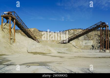 Riesige rostfreie Metallstrukturen für den Transport von Gesteinen in einem Dolomitbergbau, das Brechen von Kies, das Sortieren, das Transportieren von Gesteinen, den Hintergrund des blauen Himmels Stockfoto