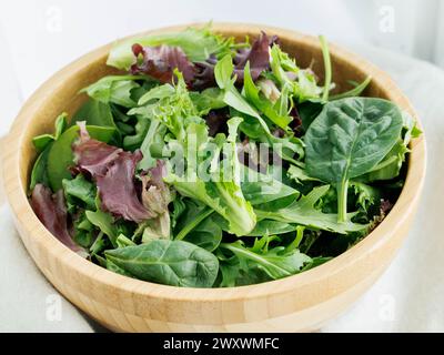 Frische Salatsorten in brauner Schüssel Stockfoto
