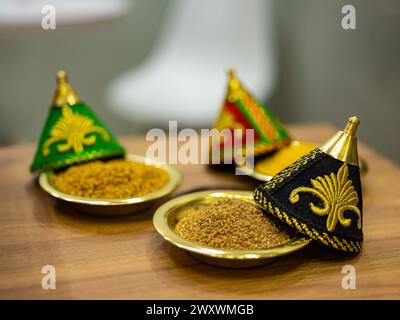 Roher Couscous in einer Schüssel mit ethnischem Motifon auf dem Tisch. Horizontale Ansicht. Kopierbereich. Ernährungsnahrungskonzept. Stockfoto