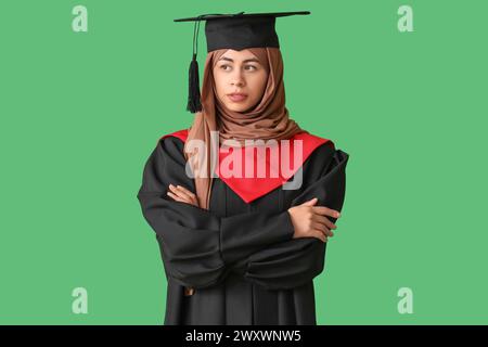 Muslimische Studentin auf grünem Hintergrund Stockfoto