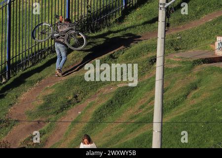 Bogota, Kolumbien, 24-01-2024. Ein Radfahrer klettert auf sein Fahrrad, lädt sein Fahrrad auf dem Rücken, während er einen Hügel hinaufklettert, um sein Zuhause in einem Viertel von Bogot zu erreichen Stockfoto