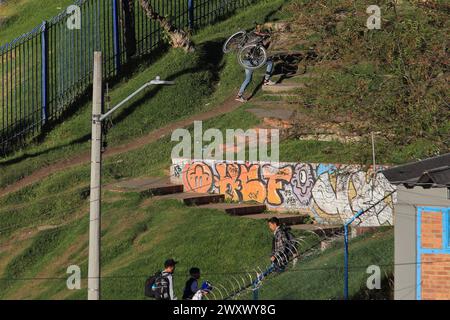 Bogota, Kolumbien, 24-01-2024. Ein Radfahrer klettert auf sein Fahrrad, lädt sein Fahrrad auf dem Rücken, während er einen Hügel hinaufklettert, um sein Zuhause in einem Viertel von Bogot zu erreichen Stockfoto