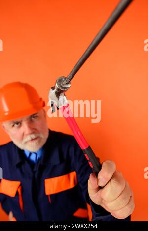 Bauarbeiter oder Meister im Helm, der Nägel mit Hammer hämmert. Selektiver Fokus. Reparaturarbeiter oder Zimmermann mit Huthämmernagel. Builder mit Stockfoto