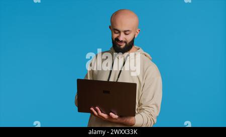 Der Mann aus dem Nahen Osten arbeitet mit Cybersicherheit auf Laptops, versucht Softwareprogrammierung durchzuführen und Fehler zu melden. Junge Erwachsene, die als Systementwickler im Studio arbeiten. Kamera 1. Stockfoto