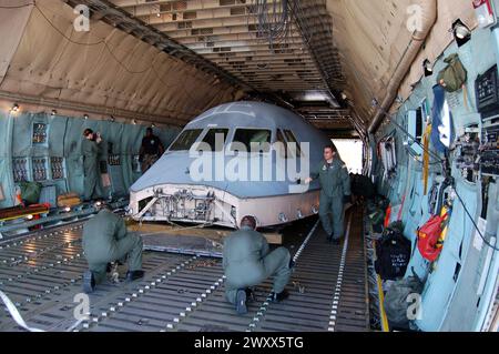 Die Piloten der 1. Klasse Ryan Harrison und Jamie Abernathy und Staff Sgt. Stuard Smith binden das gerettete Mannschaftsabteil von einer C-5 Galaxie auf eine andere C-5 für den Transport zur Robins Air Force Base, Ga, 22. August. Das Flugdeck der C-5, das am 3. April abgestürzt ist, wird als Simulator für die Ausbildung und Testung von Flugbesatzungen verwendet. (Foto der U.S. Air Force/Airman 1st Class James Bolinger) Stockfoto