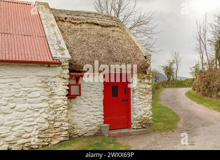 Traditionelles Haus für das frühe 20. Jahrhundert in Irland, das vom Reet auf Wellblech umsetzte Stockfoto