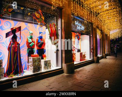 Straßburg, Frankreich - 23. Dezember 2023: Die Galeries Lafayette erstrahlt vor Feiertagsstimmung, ihre lebendigen Fenster und festlichen Lichter laden zum Zauber der Weihnachtszeit in die Stadt ein Stockfoto