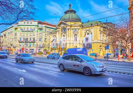 BUDAPEST, UNGARN - 3. MÄRZ 2022: Das Gebäude des Vigszinhaz Comedy Theatre hinter den Autos auf dem Szent Istvan Boulevard in Pest, Budapest, Ungarn Stockfoto